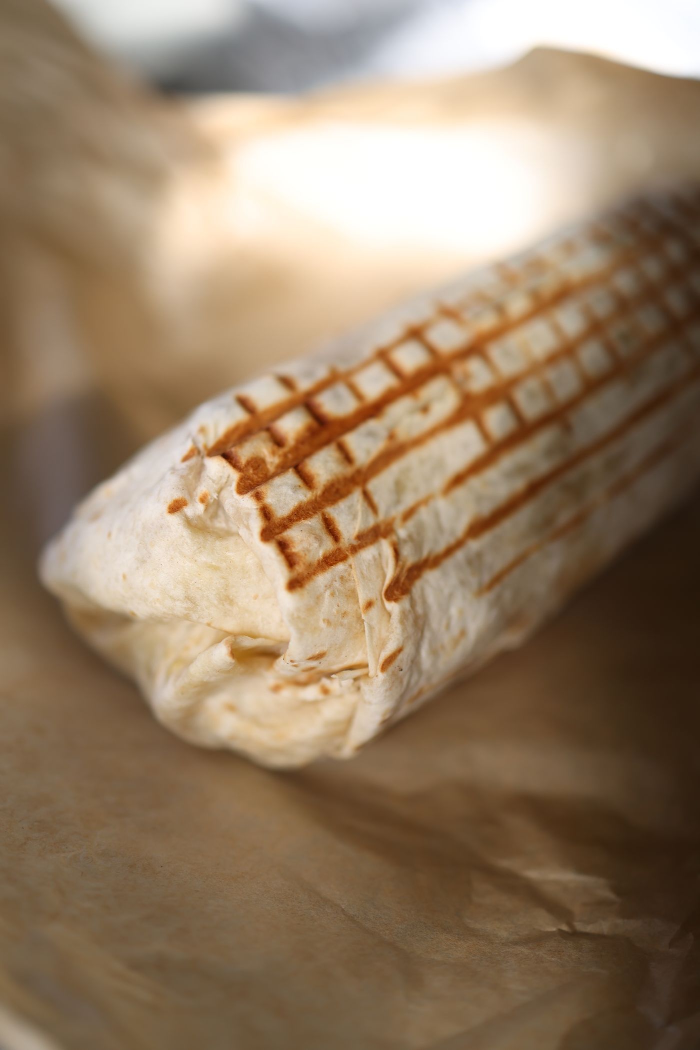 Griddled burrito filled with meat, rice and beans
